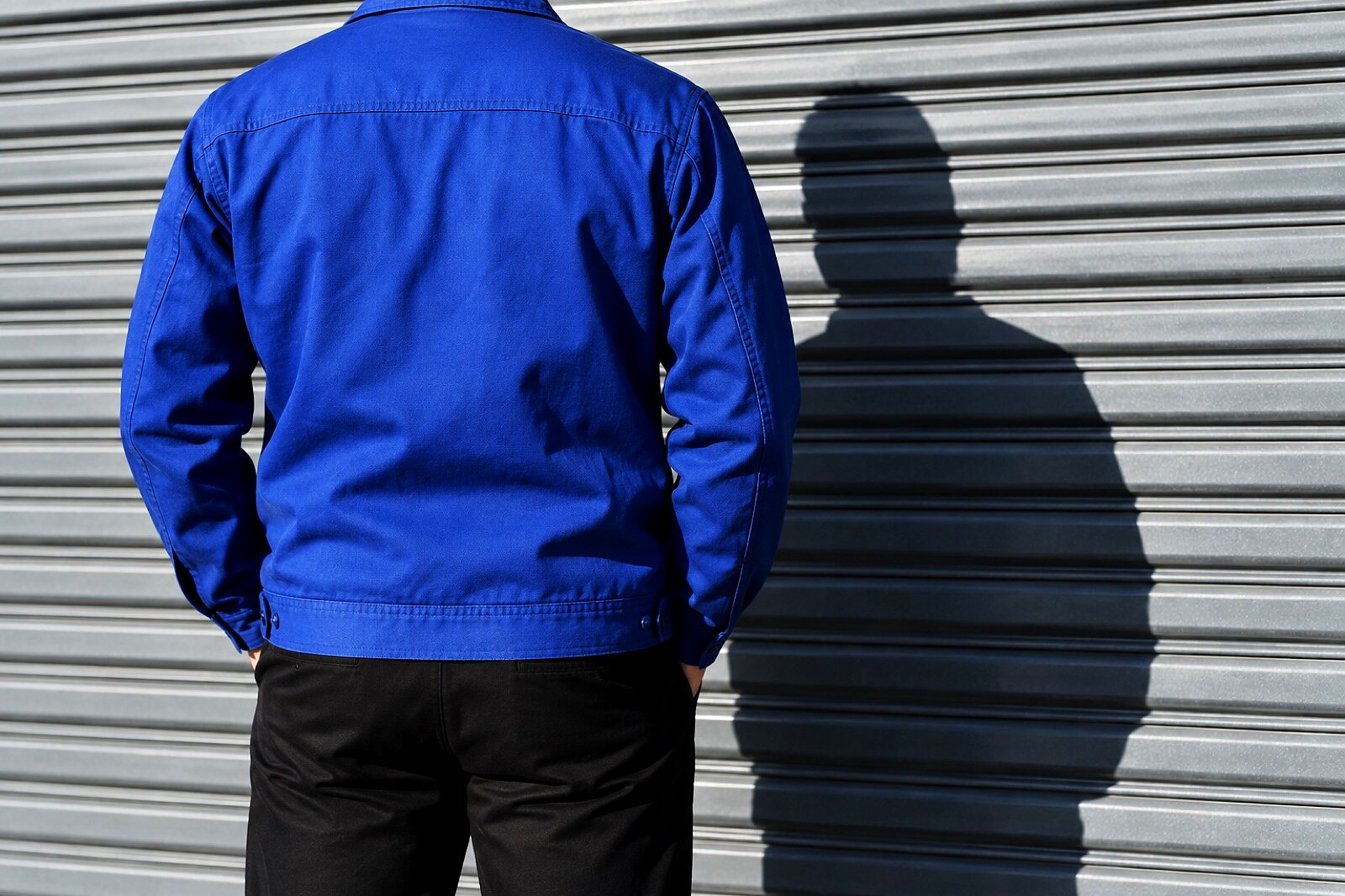 Model seated in the oxblood varsity jacket